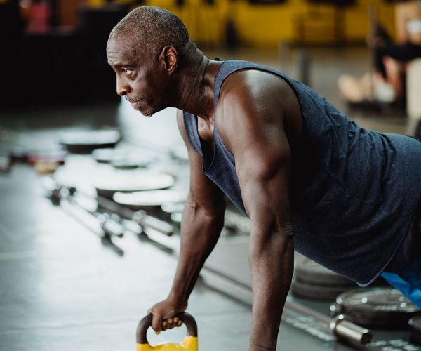 Man holding a kettlebell with focused expression, showcasing strength and stability.